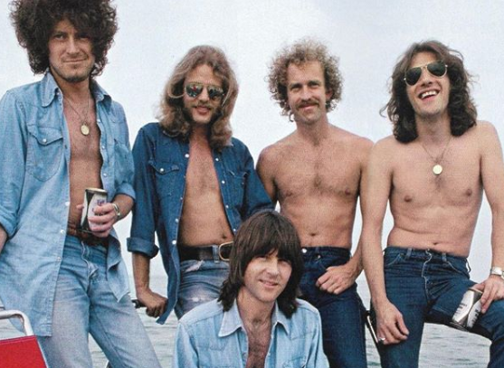 Five nearly shirtless members of the Eagles band in the early 1980's