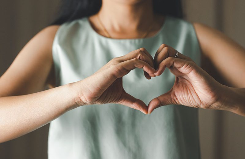 Close up of woman making heart shape for Valentines day, Mothers day and Breast Cancer Awareness month for Healthcare of International Women day