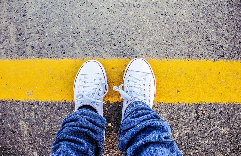 converse shoes standing on a yellow line in the road illustrating How Narcissists React to Boundaries