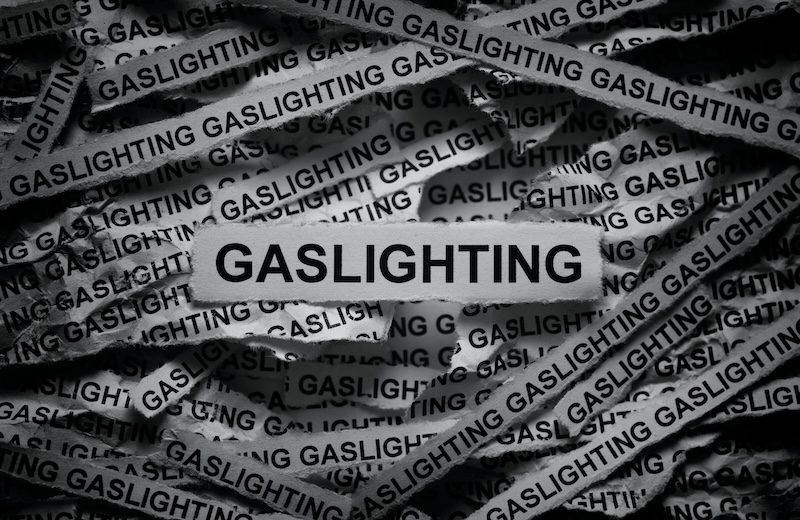 Strips of newspaper with the words Gaslighting typed on them. Black and white.