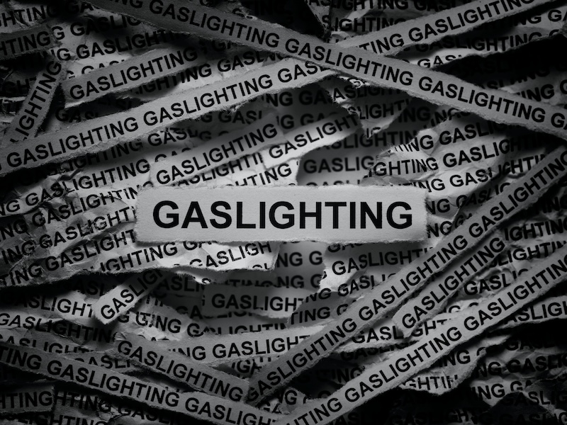 Strips of newspaper with the words Gaslighting typed on them. Black and white.