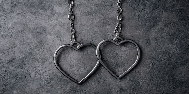 Heart-Shaped Metal Handcuffs. Creative concept of love with a prisoner, abusive relationships and jealousy crimes.